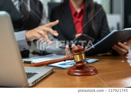 Teamwork of business lawyer meeting working hard about legal legislation in courtroom to help their customer. Teamwork of business lawyer meeting working hard about legal legislation in courtroom to help their customer. 137921745