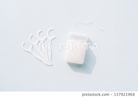 Dental floss container with several floss picks on light blue background, oral care routine concept with copy space 137921968