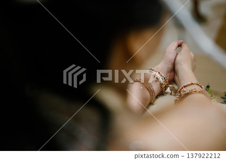 Close-up of Indian Bride's Hands with Traditional Gold Jewelry in Prayer Pose 137922212
