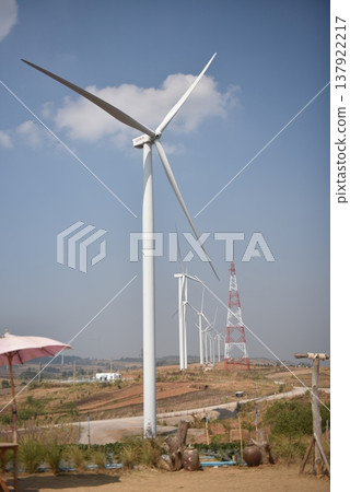 Sustainable Wind Farm with Modern Turbines and Power Tower on Rural Hills Sustainable Wind Farm with Modern Turbines and Power Tower on Rural Hills 137922217