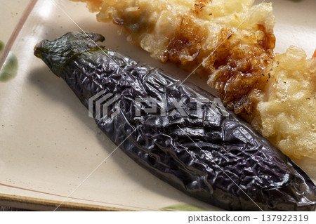 A platter of grilled eggplant and tempura, presented in a traditional Japanese style on Japanese tableware, evoking the image of Japanese summer vegetables. A platter of grilled eggplant and tempura, presented in a traditional Japanese style on Japanese tableware, evoking the image of Japanese summer vegetables. 137922319