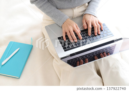 一位女士在家工作時使用電腦的雙手。 一位女士在家工作時使用電腦的雙手。 137922740