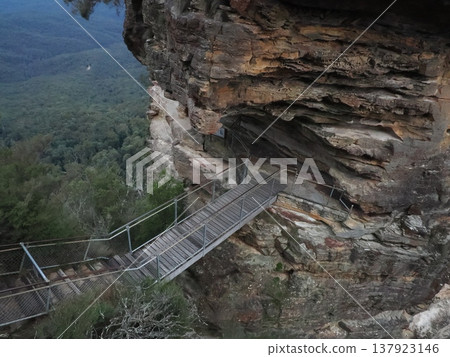 A journey guided by a narrow bridge clinging to the cliff face – the silent Blue Mountains corridor leading into the deep forest. A journey guided by a narrow bridge clinging to the cliff face – the silent Blue Mountains corridor leading into the deep forest. 137923146