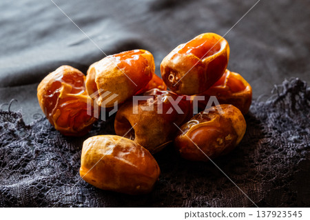 A close-up of two plates containing dates and walnuts, accompanied by cinnamon sticks prepared for Iftar at Ramadan. The scene highlights healthy snacks and natural ingredients. A close-up of two plates containing dates and walnuts, accompanied by cinnamon sticks prepared for Iftar at Ramadan. The scene highlights healthy snacks and natural ingredients. 137923545