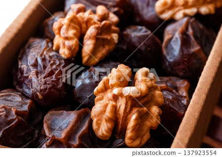 A close-up of two plates containing dates and walnuts, accompanied by cinnamon sticks prepared for Iftar at Ramadan. The scene highlights healthy snacks and natural ingredients. A close-up of two plates containing dates and walnuts, accompanied by cinnamon sticks prepared for Iftar at Ramadan. The scene highlights healthy snacks and natural ingredients. 137923554