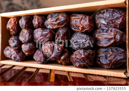 A close-up of two plates containing dates and walnuts, accompanied by cinnamon sticks prepared for Iftar at Ramadan. The scene highlights healthy snacks and natural ingredients. A close-up of two plates containing dates and walnuts, accompanied by cinnamon sticks prepared for Iftar at Ramadan. The scene highlights healthy snacks and natural ingredients. 137923555