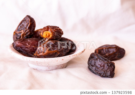 A close-up of two plates containing dates and walnuts, accompanied by cinnamon sticks prepared for Iftar at Ramadan. The scene highlights healthy snacks and natural ingredients. A close-up of two plates containing dates and walnuts, accompanied by cinnamon sticks prepared for Iftar at Ramadan. The scene highlights healthy snacks and natural ingredients. 137923598