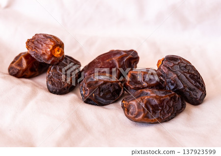 A close-up of two plates containing dates and walnuts, accompanied by cinnamon sticks prepared for Iftar at Ramadan. The scene highlights healthy snacks and natural ingredients. A close-up of two plates containing dates and walnuts, accompanied by cinnamon sticks prepared for Iftar at Ramadan. The scene highlights healthy snacks and natural ingredients. 137923599