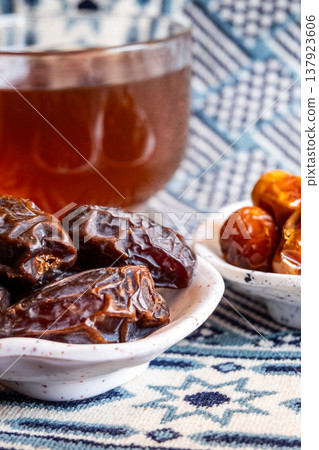 A close-up of two plates containing dates and walnuts, accompanied by cinnamon sticks prepared for Iftar at Ramadan. The scene highlights healthy snacks and natural ingredients. A close-up of two plates containing dates and walnuts, accompanied by cinnamon sticks prepared for Iftar at Ramadan. The scene highlights healthy snacks and natural ingredients. 137923606