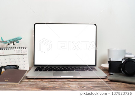 Workspace with laptop and travel items Workspace with laptop and travel items 137923726