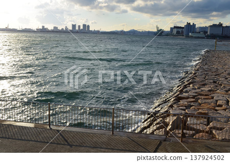 A tranquil scene capturing the coastline and seawall of Kobe. A tranquil scene capturing the coastline and seawall of Kobe. 137924502