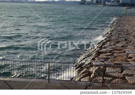 一幅寧靜的畫面，捕捉了神戶的海岸線和海堤風景。 137924504