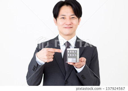 一位中年商人手持企業辦公大樓的住宅模型。 137924567