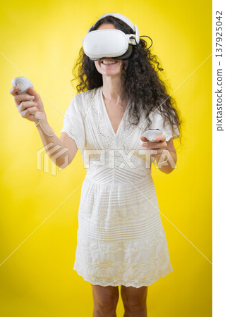Smiling woman experiencing virtual reality metaverse technology with controllers Smiling woman experiencing virtual reality metaverse technology with controllers 137925042