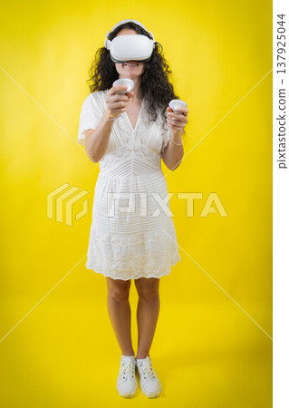 Woman experiencing virtual reality world holding controllers 137925044