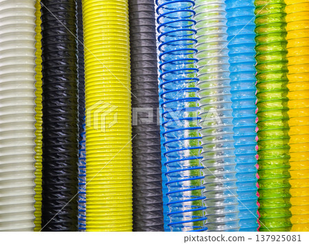 Different colors of plastic spiral tubes arranged vertically in a close view showing various shades and patterns Different colors of plastic spiral tubes arranged vertically in a close view showing various shades and patterns 137925081