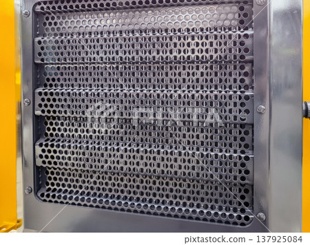 Close view of a tractor radiator showing mesh pattern and grid design for cooling efficiency under sunlight Close view of a tractor radiator showing mesh pattern and grid design for cooling efficiency under sunlight 137925084