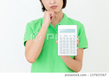 A middle-aged female care worker struggling with a calculator. A middle-aged female care worker struggling with a calculator. 137925567