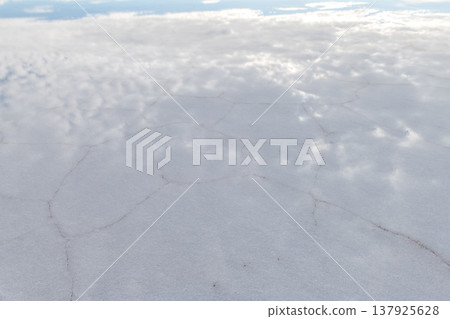 Serene vast white salt flat landscape with cracked ground in uyuni bolivia Serene vast white salt flat landscape with cracked ground in uyuni bolivia 137925628