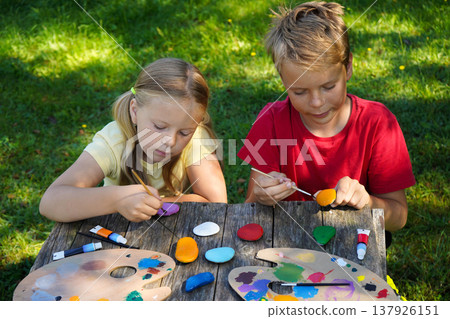 Little painters bring stones to life, expressing their dreams in vivid color to craft special DIY presents. 137926151