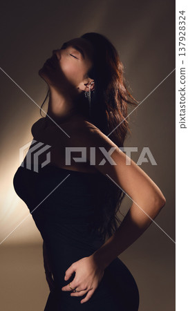 Side profile of woman with closed eyes and long hair in soft shadow light. Side profile of woman with closed eyes and long hair in soft shadow light. 137928324