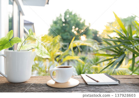 White coffee cup and stack of notebook with plant pot White coffee cup and stack of notebook with plant pot 137928603