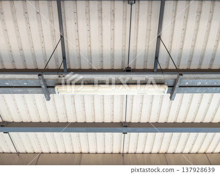 Fluorescent lamp installed on the industrial metal ceiling of the train station. Fluorescent lamp installed on the industrial metal ceiling of the train station. 137928639