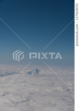 A view of Mount Rishiri appearing above the sea, seen from the airplane window. A view of Mount Rishiri appearing above the sea, seen from the airplane window. 137929070