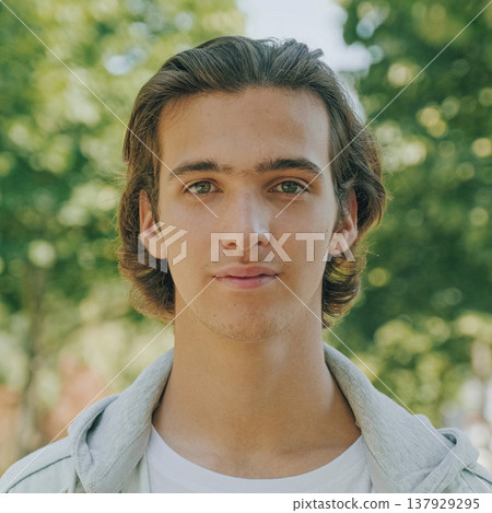 Closeup portrait of happy handsome young man at the park in summer. Cheerful teenager looks to the camera, outdoor portrait. Handsome face of a male model with brown hair at the city. One person Closeup portrait of happy handsome young man at the park in summer. Cheerful teenager looks to the camera, outdoor portrait. Handsome face of a male model with brown hair at the city. One person 137929295