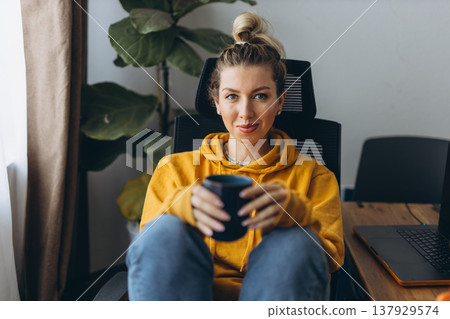 Calm woman resting with coffee in home office showing emotional recovery and self care after burnout in remote work lifestyle Calm woman resting with coffee in home office showing emotional recovery and self care after burnout in remote work lifestyle 137929574