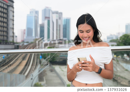 Asian Tourist Woman Using Phone in Kuala Lumpur River of Life Urban City Background 137931026