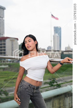 Portrait of woman against Kuala Lumpur city skyline with National Textile Museum and Malaysian flag Portrait of woman against Kuala Lumpur city skyline with National Textile Museum and Malaysian flag 137931033