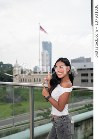 Portrait of woman against Kuala Lumpur city skyline with National Textile Museum and Malaysian flag 137931036