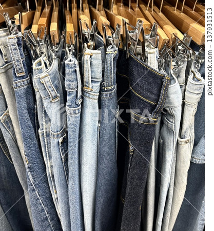 A close-up of a hanger rack in an apparel shop displaying denim pants. A close-up of a hanger rack in an apparel shop displaying denim pants. 137931513