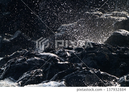 特寫鏡頭展現了洶湧的海浪拍打岩石時濺起的巨浪。 137932884