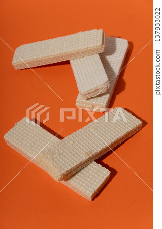 Vanilla wafers on orange background, creating sweet dessert snack Vanilla wafers on orange background, creating sweet dessert snack 137933022