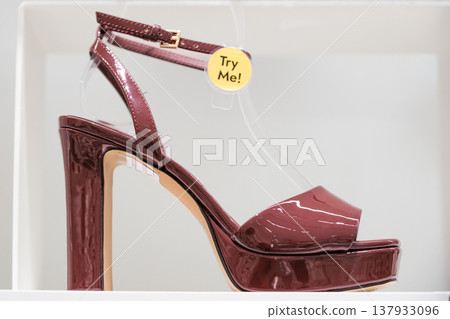 Elegant maroon high heel shoe on display for customers to try on at a retail store 137933096