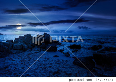 sandy beach landscape at night. full moon over coastal seascape scenery. mysterious nature background for summer vacation at the shore of black sea with rocks 137933424