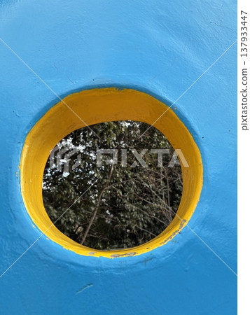 Forest visible through a hole in the park wall Forest visible through a hole in the park wall 137933447
