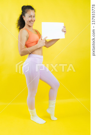 Woman smiling and pointing at blank sign with copy space Woman smiling and pointing at blank sign with copy space 137933778