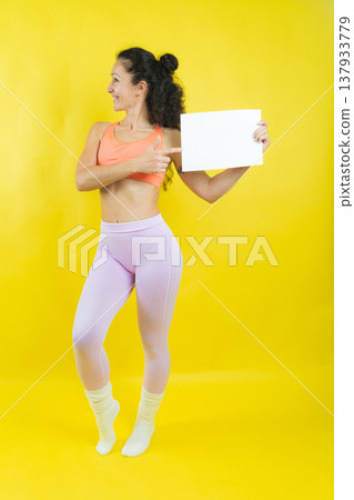 Woman pointing at blank board offering copy space Woman pointing at blank board offering copy space 137933779