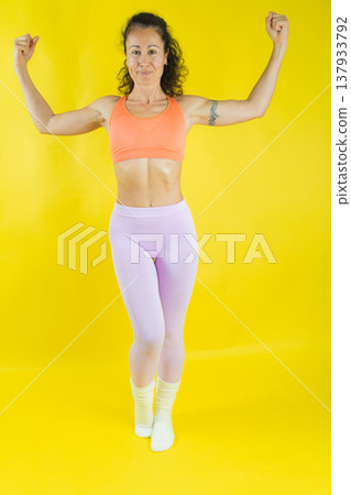 Woman posing flexing biceps showing strength Woman posing flexing biceps showing strength 137933792