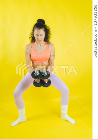 Woman exercising with dumbbells doing fitness workout Woman exercising with dumbbells doing fitness workout 137933859