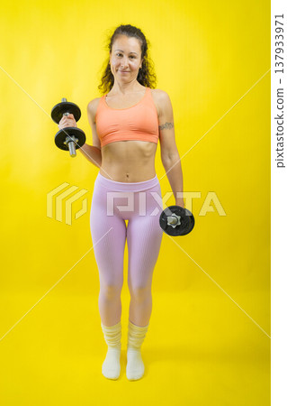 Woman exercising with dumbbells for fitness and strength Woman exercising with dumbbells for fitness and strength 137933971