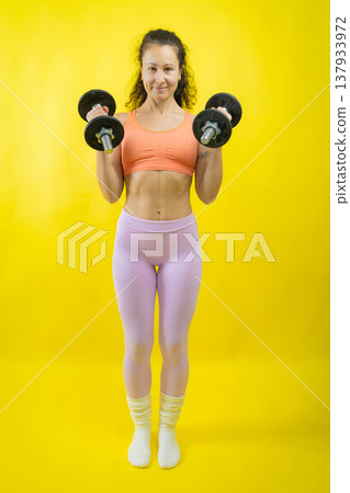 Woman exercising with dumbbells for fitness and strength Woman exercising with dumbbells for fitness and strength 137933972