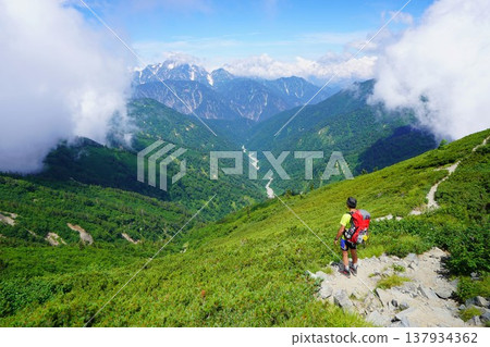 A hiker viewing Mt. Tsurugi from near Mt. Jigatake. A hiker viewing Mt. Tsurugi from near Mt. Jigatake. 137934362