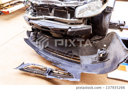 Car front parts are disassembled in an auto repair shop for maintenance inspection Car front parts are disassembled in an auto repair shop for maintenance inspection 137935266