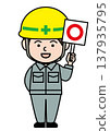 A male worker wearing a helmet and holding a circular sign. 137935795