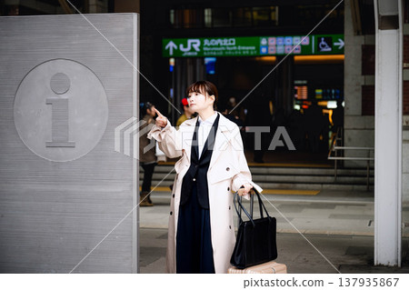 一位年輕女子查看路標以找到方向。 137935867