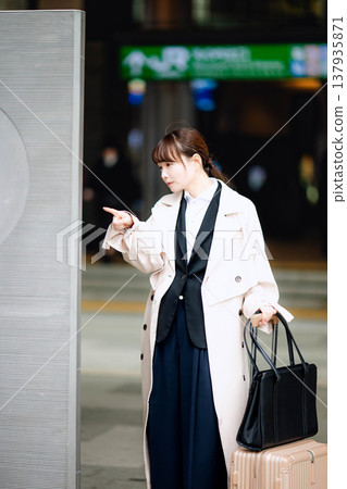 A young woman checks the signs to find her way. 137935871